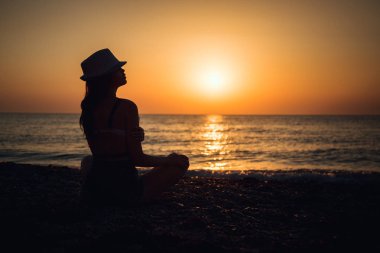 Mutlu Kaygısız Kadın Sahilde Güzel Günbatımının tadını çıkarıyor