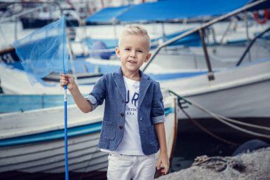 Tekne ve yatların arka planında deniz tarzında küçük bir çocuk. Fikir ve kavram Dostluk, tatil, tatil, aile