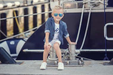 Tekne ve yatların arka planında deniz tarzında küçük bir çocuk. Fikir ve kavram Dostluk, tatil, tatil, aile