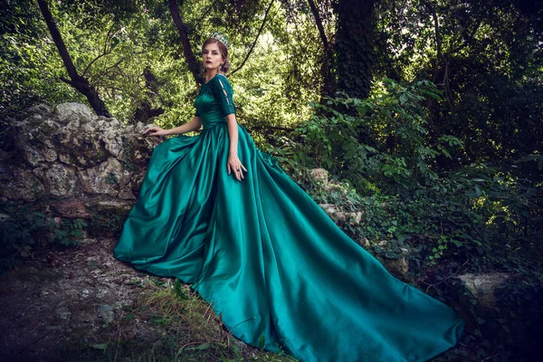 Jovem usando um vestido verde explora uma floresta mágica — Fotografia de Stock