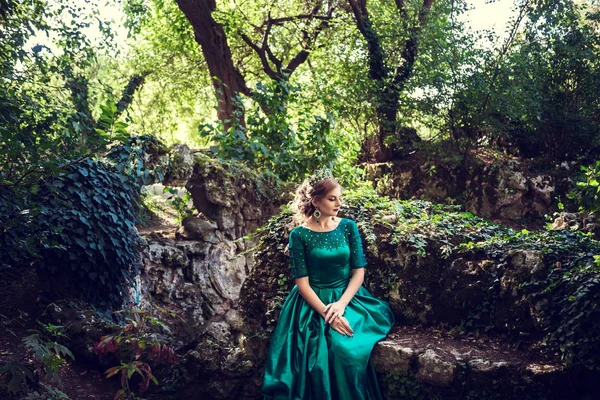 Mujer joven con un vestido verde explora un bosque mágico —  Fotos de Stock
