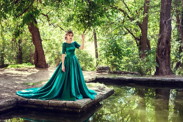 Jonge vrouw draagt een groene jurk verkent een magische forest — Stockfoto