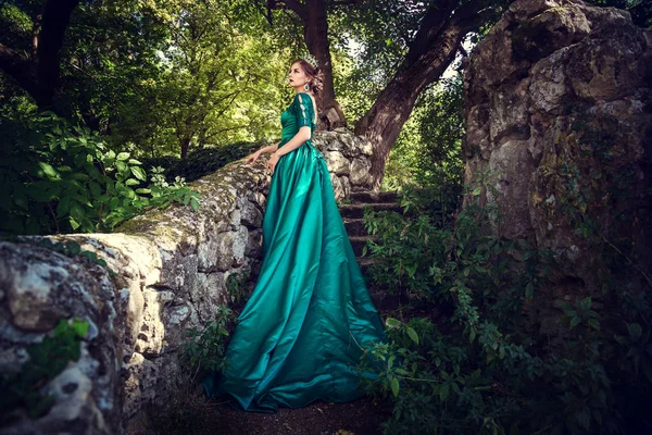 Giovane donna che indossa un abito verde esplora una foresta magica — Foto Stock