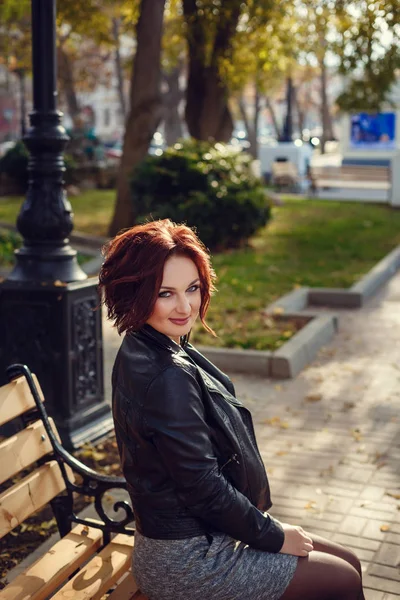 Stijlvolle jongedame dragen zwarte jas, broek en handtas wandelen in de stad straat in de val seizoen. Winter mode, elegante look. Plus size model. — Stockfoto