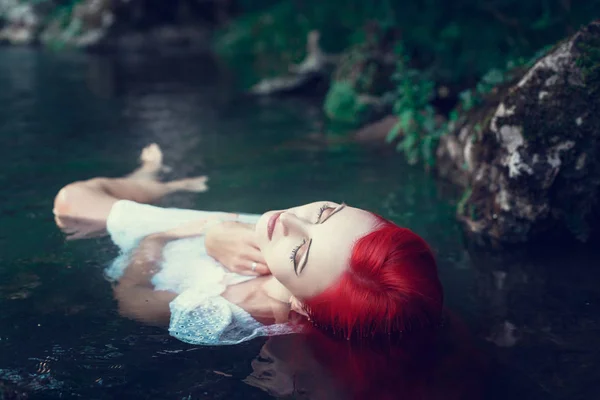 Hermosa joven descansando en el agua — Foto de Stock