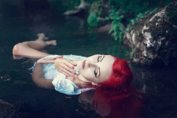 Hermosa joven descansando en el agua — Foto de Stock