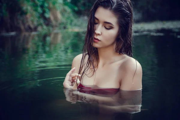 Hermosa joven descansando en el agua — Foto de Stock