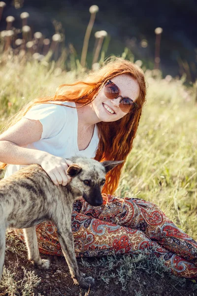 Une jeune fille dans un style boho, sur la côte avec son chien. L'idée et le concept de liberté et de hippies — Photo