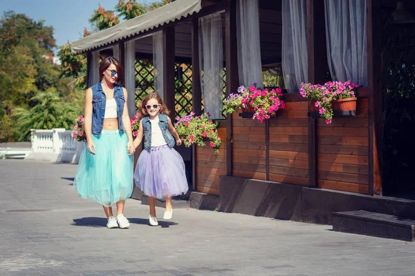 Anne ve kızı yaz tatili, bir kafede deniz kenarında gezinti boyunca geziniyor.