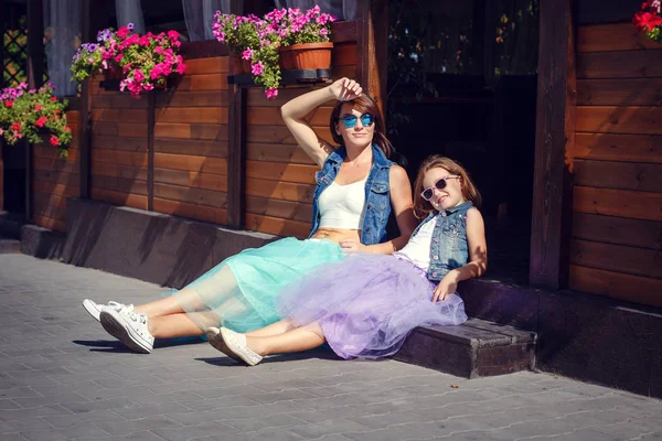 Anne ve kızı yaz tatili, bir kafede deniz kenarında gezinti boyunca geziniyor.