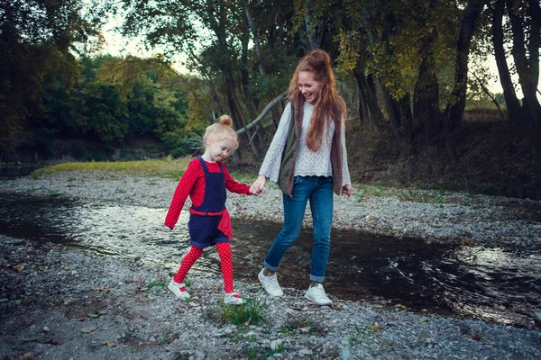 En serie om Happy rödhårig. Äldre syster och yngre bror och syster. Park, höst, flod — Stockfoto