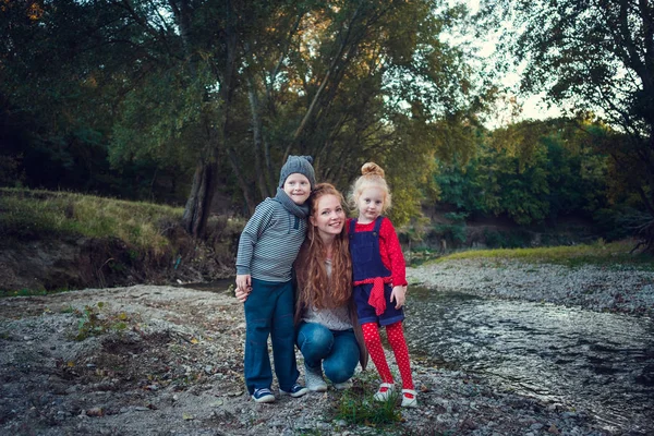 Серия о счастливых рыжих. Старшая сестра и младший брат и сестра. Парк, осень, река — стоковое фото