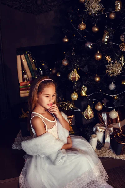 Sevimli elbise koyu bir arka plan üzerinde kahverengi saçlı küçük bir kız