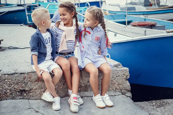 Irmã e irmão em um estilo marinho contra o pano de fundo de barcos e iates. Ideia e conceito Amizade, férias, férias, família — Fotografia de Stock