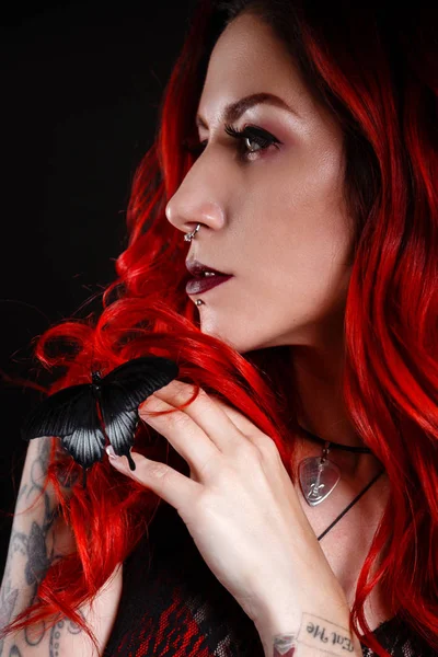 Primo piano di bella donna con tatuaggio che indossa jeans vernice corta su sfondo nero . — Foto Stock