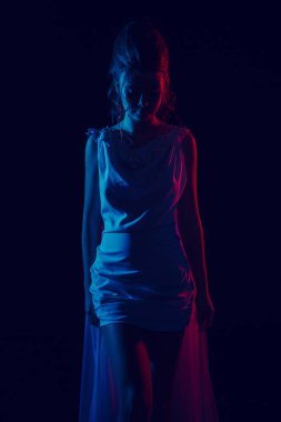 Beyaz elbiseli genç zarif kız moda portre. Siyah arka plan, stüdyo vurdu.