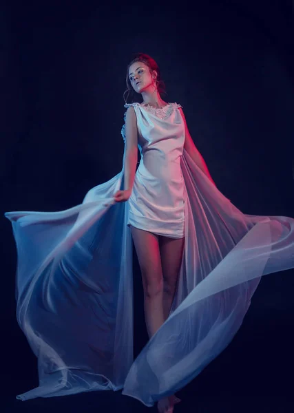 Mode portret van elegante meisje in witte jurk. Zwarte achtergrond, studio opname. — Stockfoto
