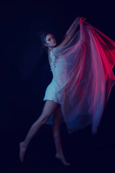 Fashion portrait of young elegant girl in white dress. Black background, studio shot. — Stock Photo, Image