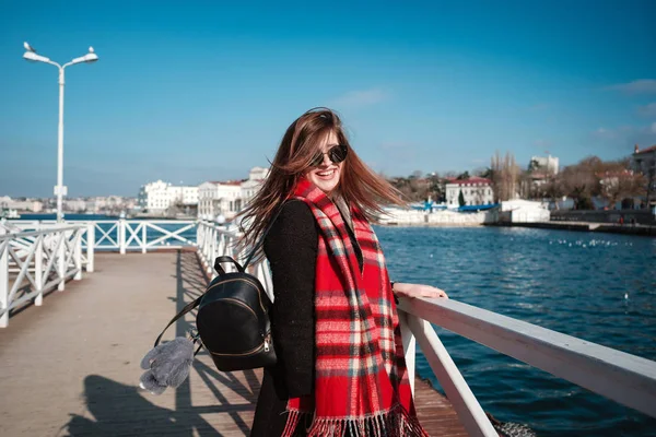 Mujer alegre caminando por la calle de la ciudad disfrutando de tiempo libre los fines de semana de primavera, mujer feliz en gafas de sol evoca el aire fresco del mar —  Fotos de Stock