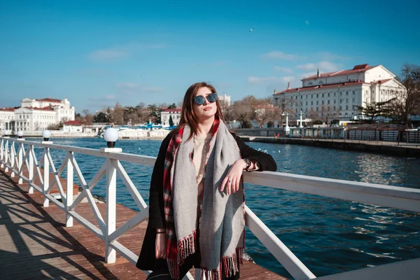 Mujer alegre caminando por la calle de la ciudad disfrutando de tiempo libre los fines de semana de primavera, mujer feliz en gafas de sol evoca el aire fresco del mar — Foto de Stock