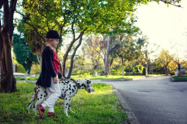 Bahar parkında Dalmaçyalı köpekleriyle genç bir kız.