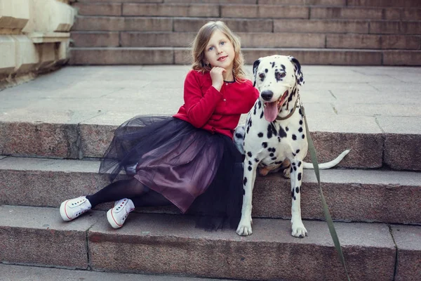 Jeune fille avec ses chiens dalmates dans un parc de printemps — Photo