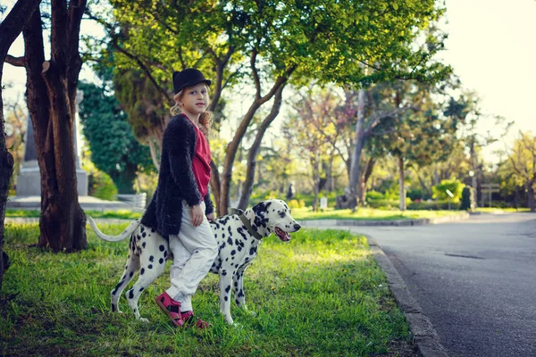 Junges Mädchen mit ihren Dalmatinerhunden in einem Frühlingspark — Stockfoto