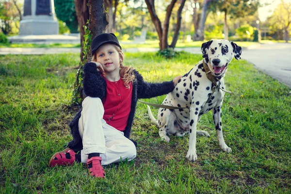 Young girl with her Dalmatian dogs in a spring park