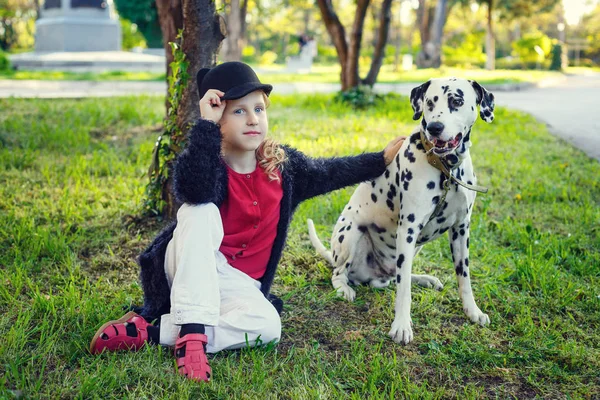 Young girl with her Dalmatian dogs in a spring park