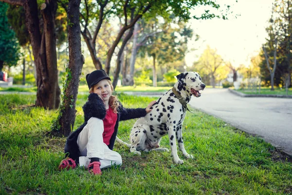 Young girl with her Dalmatian dogs in a spring park