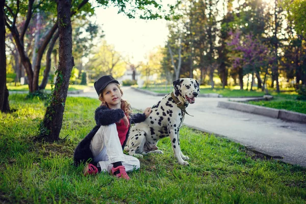 Jeune fille avec ses chiens dalmates dans un parc de printemps — Photo