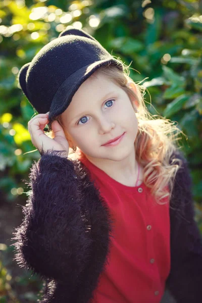 Belle petite fille dans un chapeau mignon avec des oreilles dans le parc du soir — Photo