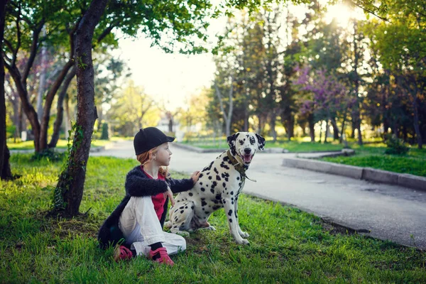 Junges Mädchen mit ihren Dalmatinerhunden in einem Frühlingspark — Stockfoto