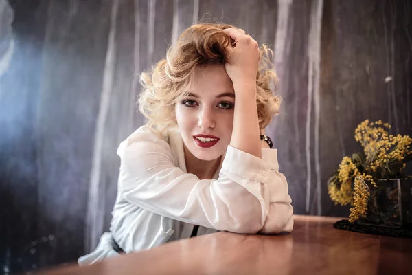 Beautiful young woman in a stylish white shirt and pants in anticipation of a date. — Stock Photo, Image