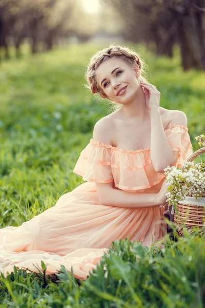 Menina bonita em um vestido velho em um jardim florescente de pêra . — Fotografia de Stock