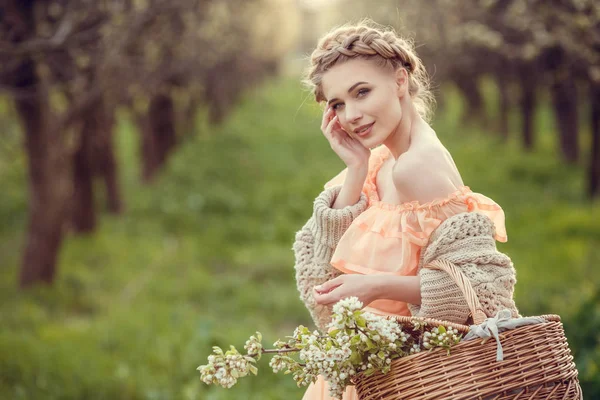 Krásná mladá dívka ve starém obleku v zahradě z hruškovitého květu. — Stock fotografie