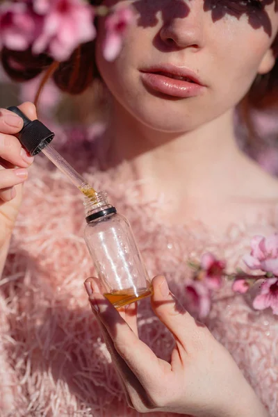 Mooi meisje met rode haren in een zachte perzik Tuin, die bloeide. — Stockfoto