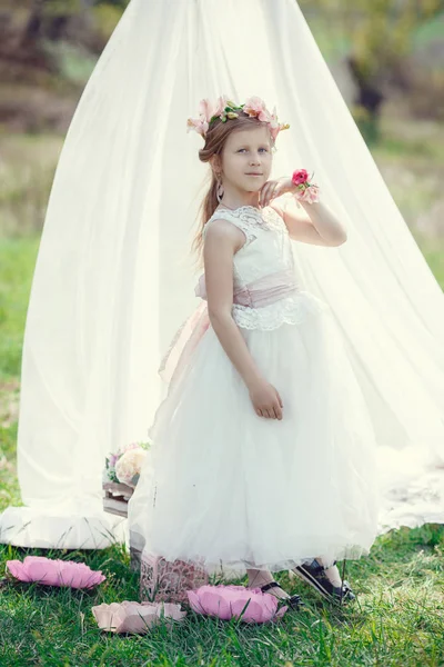 Μια μικρή ξανθιά Ευρωπαϊκή κοπέλα με ένα όμορφο φόρεμα ποζάρει κοντά στο τοπίο στο χωράφι. — Φωτογραφία Αρχείου