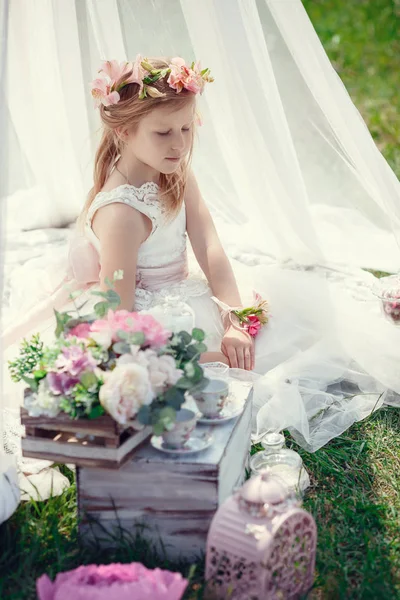 A small blonde European girl in a beautiful dress poses near the scenery in the field. — Stock Photo, Image