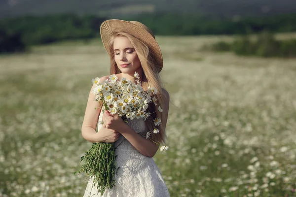 Vacker kvinna njuter daisy fältet — Stockfoto