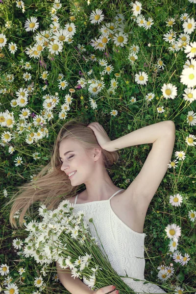 Mulher bonita desfrutando de campo de margarida — Fotografia de Stock