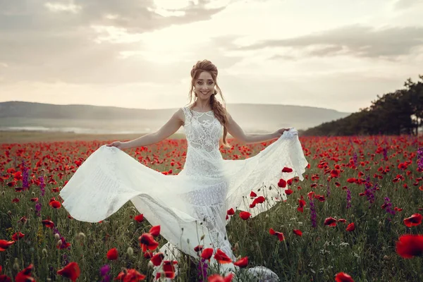 Mulher de beleza no campo de papoula em vestido branco — Fotografia de Stock