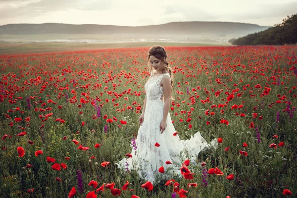 Schönheit Frau in Mohnfeld in weißem Kleid — Stockfoto