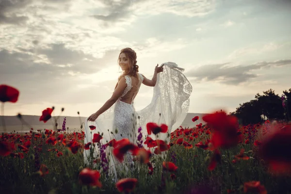 Krása ženy v makovém poli v bílých šatech — Stock fotografie