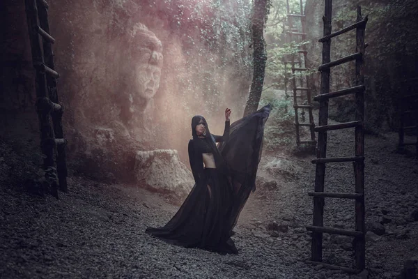 Una mujer hermosa con la piel pálida en un vestido negro y en la corona negra. Mirada gótica. Traje para Halloween . — Foto de Stock