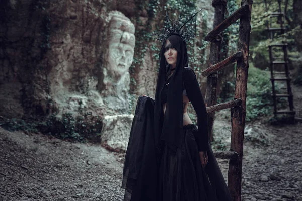 En kvinna är en profet trollkarl och en predikant i en svart mystiska kappa — Stockfoto