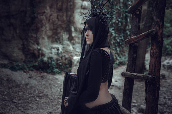 Женщина колдун-пророк и проповедник в черной мистической мантии.
