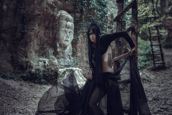Une femme est un prophète sorcier et un prédicateur dans un manteau mystique noir — Photo