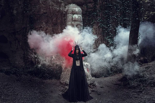 Een mooie vrouw met bleke huid in een zwarte jurk en de zwarte crownk. Gothic look. Outfit voor halloween. — Stockfoto