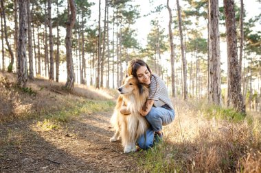 Collie köpek ile yürüyen genç güzel kadın.